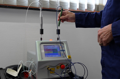 Close-up van een technicus die een medisch laserapparaat bedient.