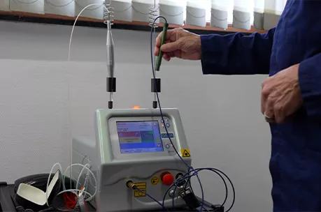 Close-up van een technicus die een medisch laserapparaat bedient.