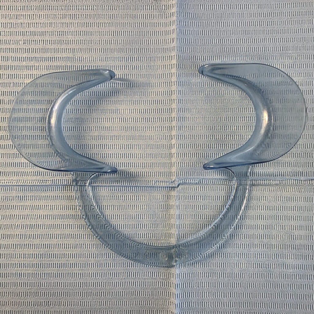nanowhite_tandenbleken Een paar doorzichtige, plastic bijtblokjes op een blauw vel keukenpapier.
